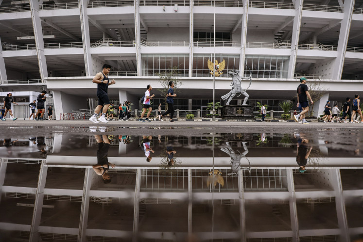 People exercise on Feb. 22, 2026, along the promenade surrounding the Main Stadium at the Gelora Bung Karno Sports Complex in Senayan, Central Jakarta. (Antara/Dhemas Reviyanto)