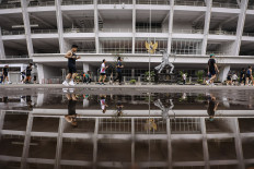 People exercise on Feb. 22, 2026, along the promenade surrounding the Main Stadium at the Gelora Bung Karno Sports Complex in Senayan, Central Jakarta. (Antara/Dhemas Reviyanto)