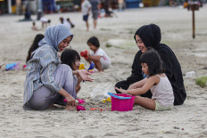 Saltwater break: Visitors play along the shore at Lagoon Beach in Taman Impian Jaya Ancol, Jakarta, on Feb. 21, 2026. As screens dominate daily routines, many Indonesians are rediscovering simple pleasures away from the glow of their phones. Antara/Darryl Ramadhan