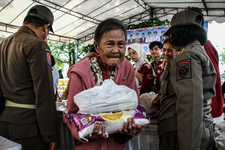An elderly person carries a staple food package on March 10, 2026, that was distributed at the courtyard of the Darussalam Palangka Raya Great Mosque in Palangka Raya, Central Kalimantan. The provincial administration held a low-cost market operation providing various food staples at prices below market rates to help stabilize supply and prices ahead of the Idul Fitri holiday.