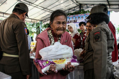 An elderly person carries a staple food package on March 10, 2026, that was distributed at the courtyard of the Darussalam Palangka Raya Great Mosque in Palangka Raya, Central Kalimantan. The provincial administration held a low-cost market operation providing various food staples at prices below market rates to help stabilize supply and prices ahead of the Idul Fitri holiday.