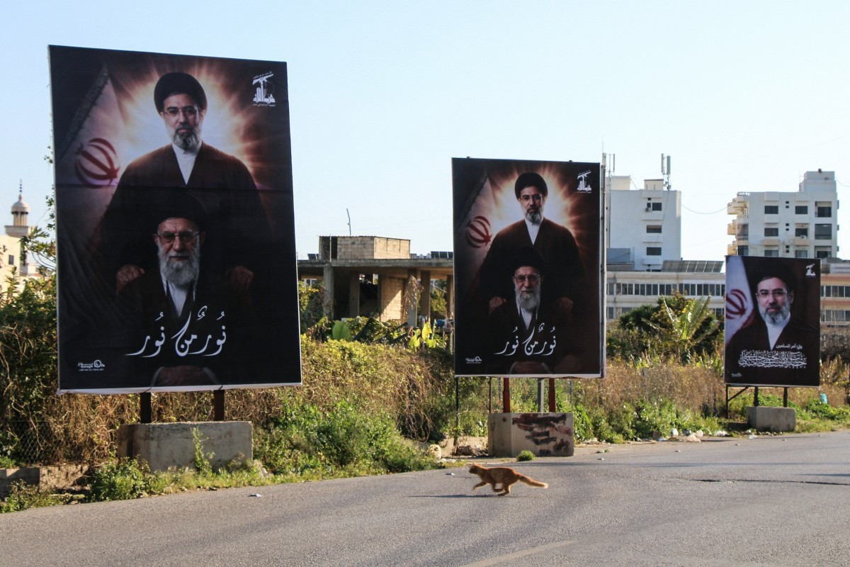 A photograph shows billboards depicting Iran's slain supreme leader Ayatollah Ali Khamenei and his son, Iran's new supreme leader Ayatollah Mojtaba Khamenei, displayed at the entrance to the southern Lebanese coastal city of Tyre on March 10, 2026.