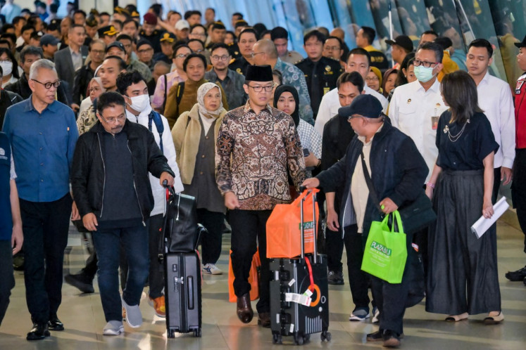 Foreign Minister Sugiono (center) walks alongside Indonesians evacuated from Iran at Soekarno-Hatta International Airport in Tangerang, Banten on March 10, 2026 amid the United States-Israeli conflict with Iran.