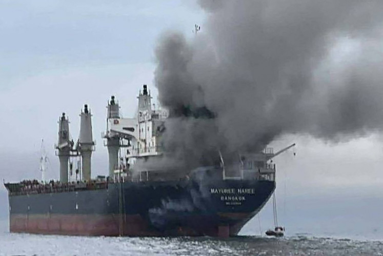 This handout photo taken on March 11, 2026 and released by the Royal Thai Navy shows smoke rising from the Thai bulk carrier 'Mayuree Naree' near the Strait of Hormuz after an attack. A Thai bulk carrier traveling in the crucial Strait of Hormuz was attacked March 11, with 20 crew members rescued so far, the Thai navy said. 