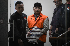Former religious affairs minister and graft suspect Yaqut Cholil Qoumas (center) is escorted out of the Corruption Eradication Commission (KPK) headquarters in Jakarta after an interrogation session on March 12, 2026. The antigraft body arrested the former minister one day after a court rejected his pretrial motion challenging his suspect status.