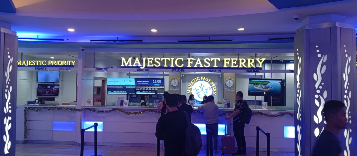 Passengers line up on March 13 at a Majestic Fast Ferry booth to buy ferry tickets heading to Malaysia and Singapore at Batam Center International Ferry Terminal in Batam, Riau Islands. Ferry operators have added fuel surcharge for routes to Singapore following the United States-Israel war on Iran.