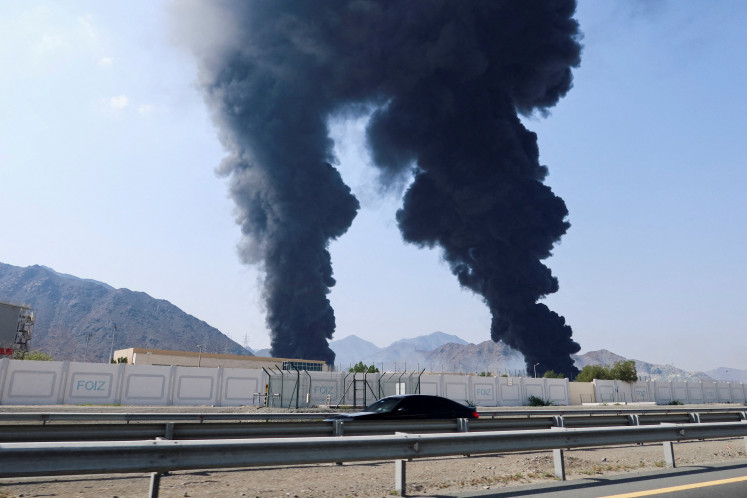 Smoke rises in the Fujairah oil industry zone, caused by debris after interception of a drone by air defenses, according to the Fujairah media office, amid the US-Israel conflict with Iran, in Fujairah, United Arab Emirates, on March 14, 2026.