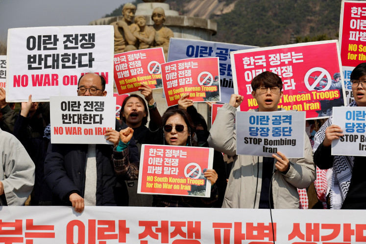 Activists hold placards during a rally against the US demand for South Korea to deploy troops to the Strait of Hormuz, outside the presidential Blue House in Seoul, South Korea, March 16, 2026. 