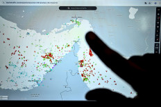 A person points at a page on the Marinetraffic website that shows commercial shipping traffic on the edge of the Strait of Hormuz near the Iranian coast, on March 4 in Paris. 