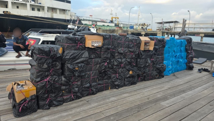 Batam Customs and Excise Office stacks 115 cardboard boxes of cigarettes, consisting of 640,000 H-Mind cigarettes and 480,000 OFO Bold cigarettes, in front of an impounded speedboat at Tanjung Uncang pier in Batam city, Riau Islands, in this picture issued on March 16. The contraband cigarettes without excise stamps are estimated to be worth Rp 1.66 billion (US$97.733).