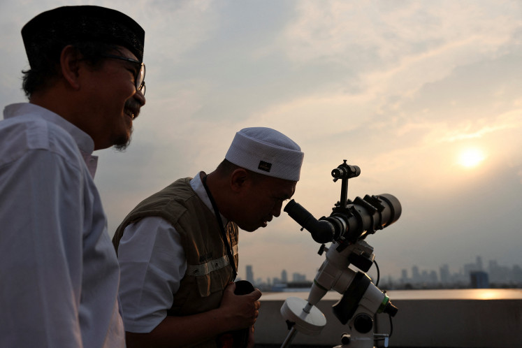 Officials use a telescope to observe the position of the moon on March 19, 2026, ahead of Idul Fitri, marking the end of the Muslim holy fasting month of Ramadan, in Jakarta.