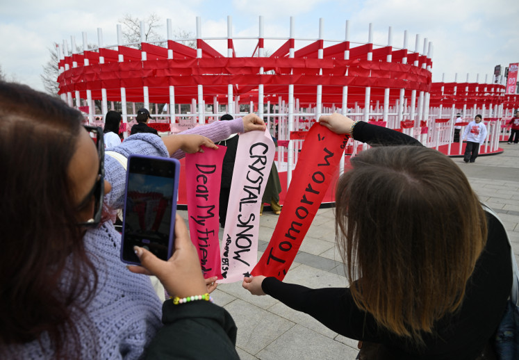 BTS fans take a picture of banners inscribed with their love songs at a fan zone promoting the new album of K-pop boy band BTS at a riverside park in Seoul on March 20, 2026.
K-pop megastars BTS releases the new album &ldquo;ARIRANG&ldquo; on March 20, billed as reflecting the maturing boy band's Korean roots and identity, as buzz builds ahead of their open-air comeback concert in the heart of Seoul.