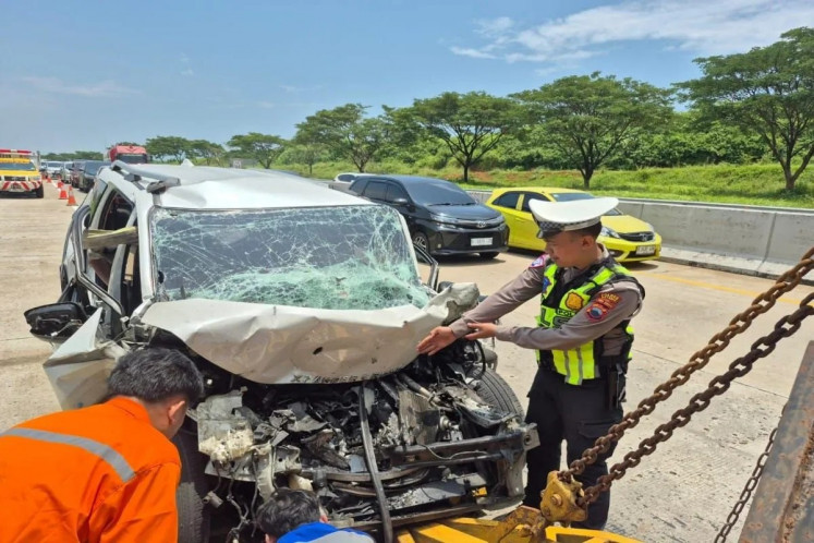 A Batang Police traffic officer (right) guides two workers on March 19, 2026, at the Semarang&ndash;Batang toll road while evacuating the wreckage of a Mitsubishi Xpander after an accident in Kedawung village, Banyuputih district, Batang regency, Central Java. Two people died in the accident while two others were injured. 