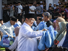 President Prabowo Subianto (center) distributes packets of 'sembako' food on March 21, 2026, to survivors of the natural disasters in Aceh Tamiang, Aceh. Prabowo performed the Idul Fitri prayer at Darussalam Mosque in Aceh Tamiang. &nbsp;

