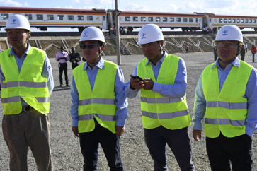 Contractors from China Commmunication Construction Company (CCCC) stand next to the Standard Gauge Railway (SGR) train at Mai Mahiu, on Oct. 16, 2019. The Standard Gauge Railway, built from 2013 to 2019, connects the Kenyan port of Mombasa to its capital Nairobi, and on to the lake town of Naivasha.