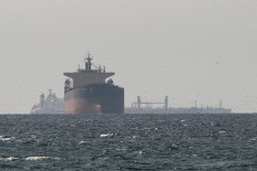 In this file photo dated March 11, 2026, cargo ships in the Gulf, near the Strait of Hormuz, as seen from northern Ras al-Khaimah, near the border with Oman&rsquo;s Musandam governance, amid the US-Israeli conflict with Iran, in the United Arab Emirates.