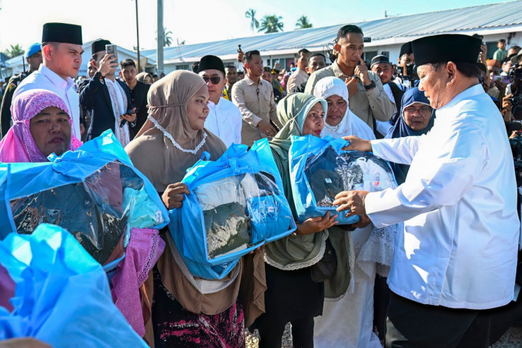 President Prabowo Subianto (left) distributes food aid packages on March 21, 2026, to flood victims after performing Idul Fitri prayers, marking the end of the holy month of Ramadan, at the Darussalam Mosque in Aceh Tamiang, Aceh.