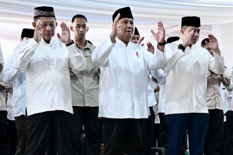 President Prabowo Subianto (center), standing between Home Minister Tito Karnavian (left) and Cabinet Secretary Teddy Indra Wijaya (right), performs Idul Fitri prayers at the Darussalam Mosque in Aceh Tamiang, Aceh, on March 21, 2026.