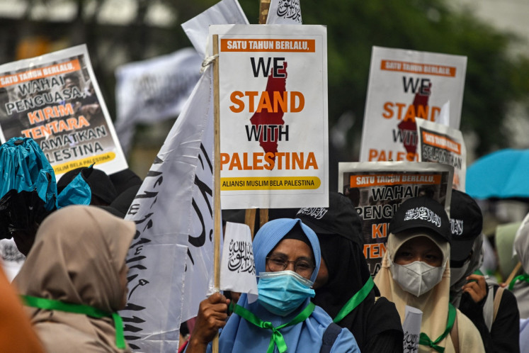 Muslim women hold picket signs on Feb. 2, 2025, during a demonstration to show support for Palestinians and to demand the end of the war in Gaza in Surabaya, East Java.