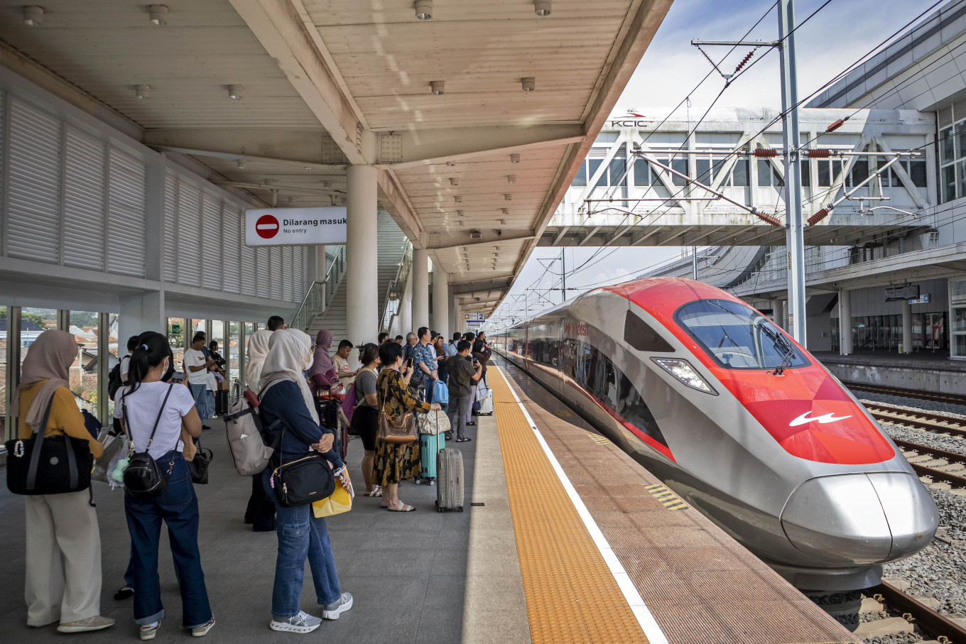 Passengers wait on a platform as a train arrives on March 15, 2026, at KCIC Padalarang Station in West Bandung regency, West Java, serving the Whoosh high-speed rail operated by PT Kereta Cepat Indonesia China (KCIC).