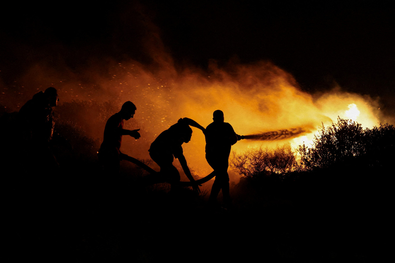 Locals try to extinguish a wildfire burning in Keratea, near Athens, Greece on August 8, 2025.