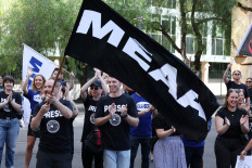 A man waves a Media Entertainment and Arts Alliance (MEAA) union flag as ABC staff and journalists strike outside the national broadcaster&rsquo;s headquarters in Sydney, Australia, March 25, 2026.