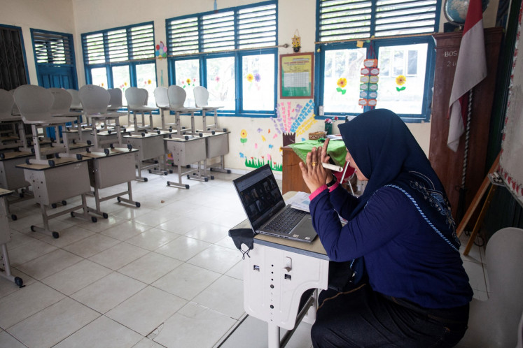 Eli Triana, 43, leads an online learning session on Oct. 5, 2023, from her classroom at an elementary school in Palembang, South Sumatra, after local authorities ordered the change due to worsening air quality from wildfires in the province.