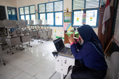 Eli Triana, 43, leads an online learning session on Oct. 5, 2023, from her classroom at an elementary school in Palembang, South Sumatra, after local authorities ordered the change due to worsening air quality from wildfires in the province.