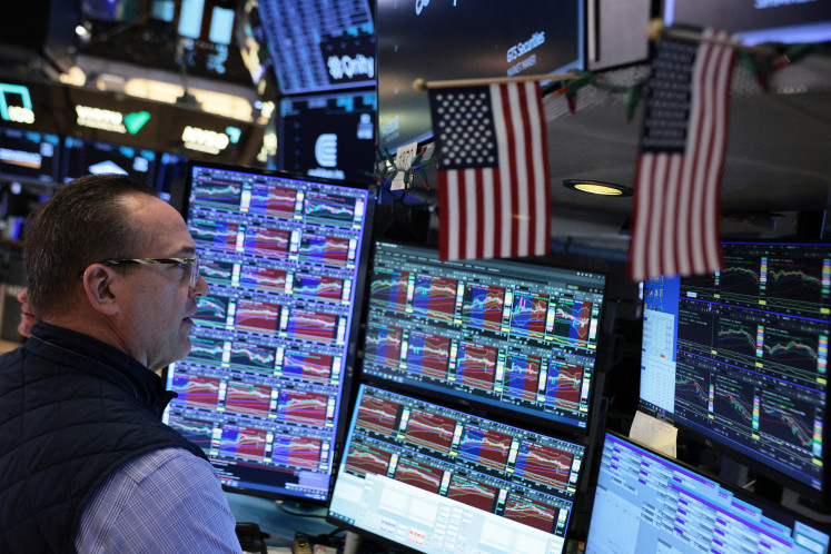 Traders work on the floor of the New York Stock Exchange during morning trading on March 25, 2026 in New York City.