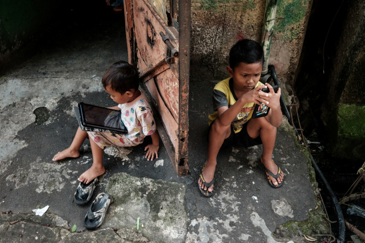 Children use portable digital devices on May 4, 2025, in Jakarta.