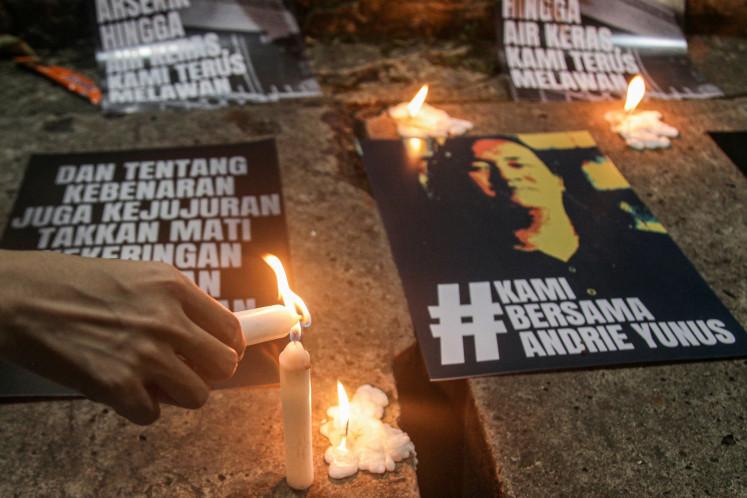 An activist light up a candle during a prayer gathering on March 17 for Andrie Yunus, a Commission for Missing Persons and Victims of Violence (Kontras) activist targeted in an acid attack, in front of the National Commission on Human Rights (Komnas HAM) in Jakarta.