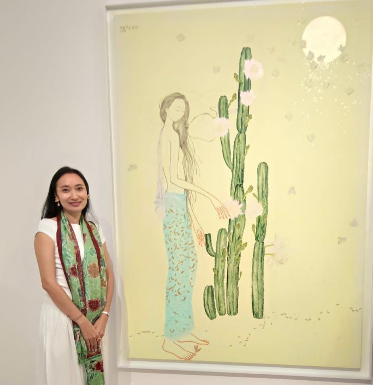 Balinese artist Satya Cipta stands in front of her work, &lsquo;The Moon Falls Quietly in My Hands&rsquo;, which is being exhibited in the Critically Bali group exhibition from March 7 to 29 at Gajah Gallery in Tanah Abang, Central Jakarta, in this undated photo.