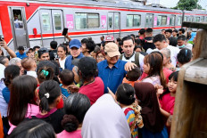 President Prabowo Subianto (center) greets a child on Thursday during his impromptu visit to an impoverished community in Senen, Central Jakarta. The President, accompanied by Cabinet Secretary Teddy Indra Wijaya (left) and a small security detail, reportedly promised to build proper housing and sanitary facilities for residents in the area.
