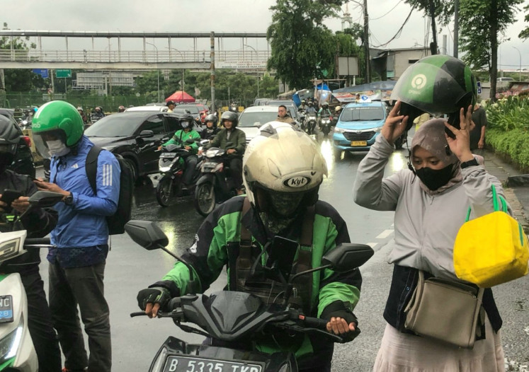 Final stop: An ojol (online motorcycle transportation) driver drops off a passenger on Jan. 14, 2026 in front of a shopping mall in East Jakarta.