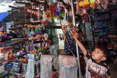 A boy reaches for a toy on March 23, 2026, at Gembrong Market in Jatinegara, East Jakarta.