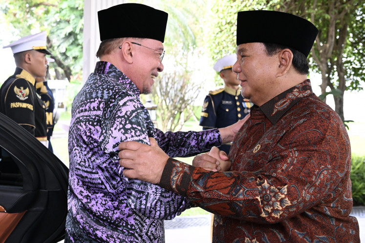 President Prabowo Subianto (right) greets Malaysian Prime Minister Anwar Ibrahim on Friday upon the latter's arrival at the Presidential Palace complex in Jakarta. Both leaders held the private meeting to discuss latest geopolitical developments, particularly the impacts of the United States-Israeli war against Iran on the Southeast Asian countries.