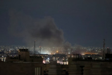 A plume of smoke rises from the site of a strike in Tehran early on March 28, 2026.