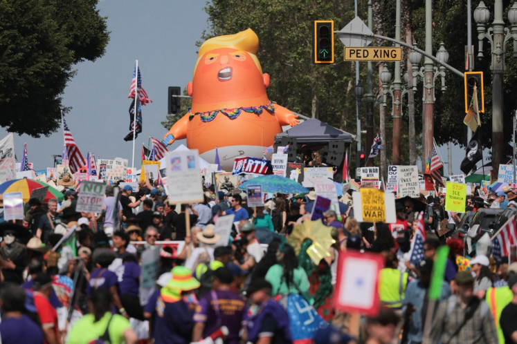 A giant inflatable Donald Trump ballon is seen while protestors gather in front of Los Angeles City Hall during the &ldquo;No Kings&ldquo; national day of protest in Los Angeles on March 28, 2026. 