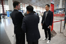 Zhao Bin, a Chinese business traveler (right), speaks to media after checking in for a flight to Pyongyang, North Korea, at Beijing airport on March 30, 2026. Air China restarted direct flights between Beijing and Pyongyang on March 30 after a six-year hiatus, another sign isolated North Korea is gradually opening up following the resumption of train services between the capitals.