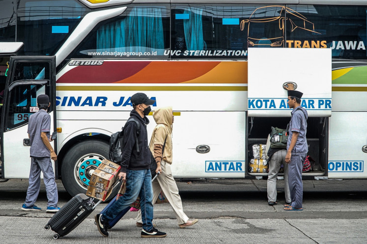 Passengers disembark on March 24, 2026, from an intercity coach at the Kampung Rambutan bus terminal in East Jakarta, amid the post-Idul Fitri 'balik' (return) travel surge after the Islamic holiday.