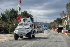 United Nations peacekeepers with the UN Interim Force in Lebanon (UNIFIL) drive past a Lebanese army outpost on March 27 in the area of Naqura in southern Lebanon.