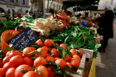 A shopper buys fruits and vegetables at a market in Aix-en-Provence, France, on Jan. 16, 2025.