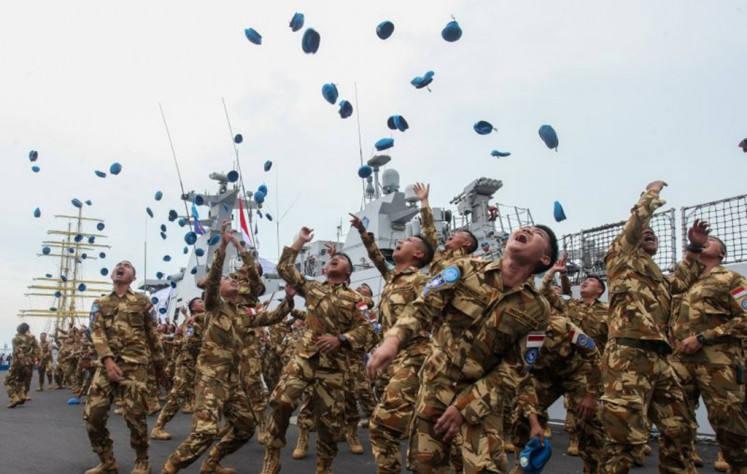 Personnel of Garuda Contingent XXVIII-P/UNIFIL's Maritime Task Force celebrate on Feb. 7 by throwing their berets into the air after disembarking from KRI Sultan Iskandar Muda  in Surabaya, East Java. The warship, carrying 120 Indonesian Navy personnel, returned to Surabaya after finishing a United Nations peacekeeping mission in Lebanon.
