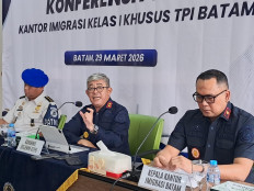 Head of Riau Islands regional office of the Immigration Directorate General, Ujo Sujoto (center), speaks, while flanked by Batam Immigration Office head Hajar Aswad (right) and an official from the Internal Compliance Directorate, Washington Napitupulu, during a press conference at Batu Ampar Immigration checkpoint in Batam, Riau Islands, on March 29, 2026. 