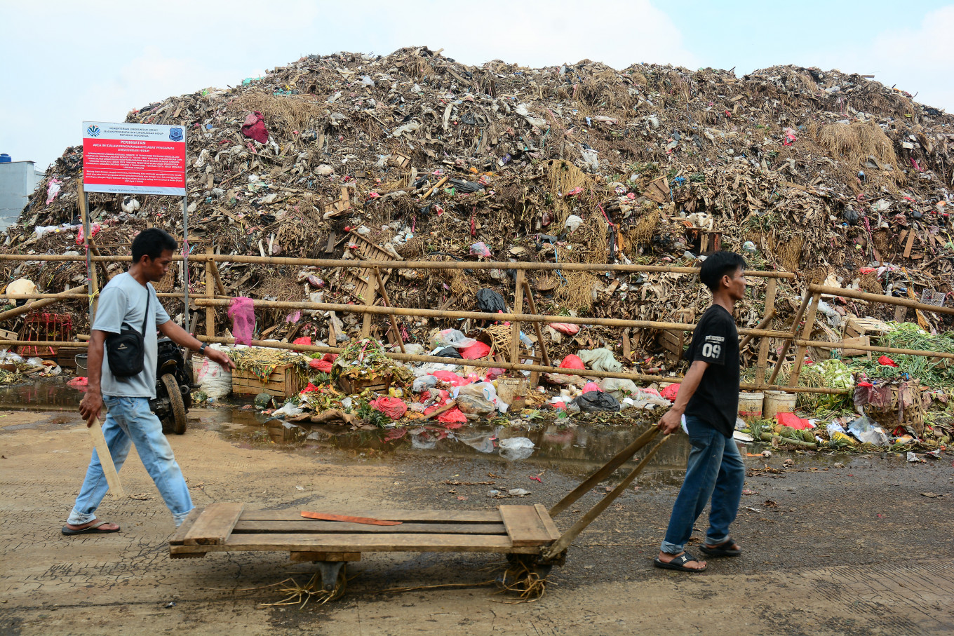 Workers walk past piles of garbage on Wednesday at Kramat Jati market in East Jakarta.