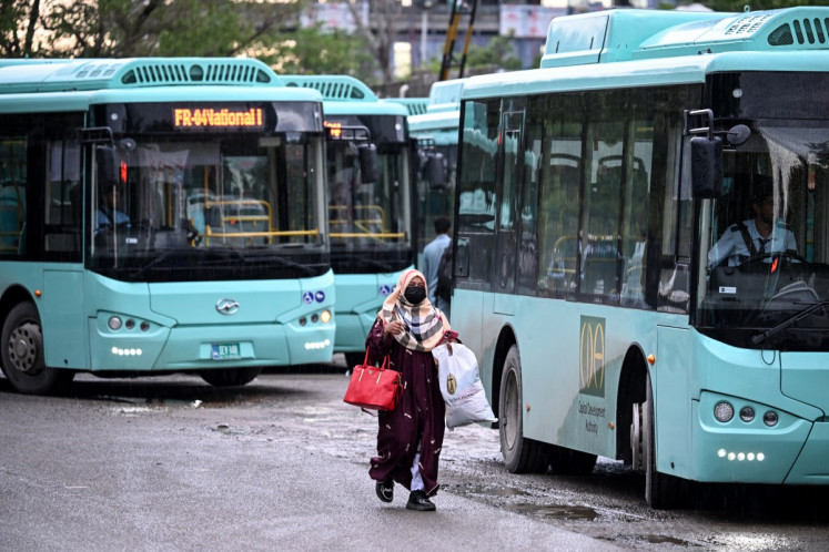 A woman passenger arrives at a government bus stop in Islamabad, Pakistan on April 3, 2026. State-run public transport in Pakistan's capital and most populous province will be free for the coming month, officials said on April 3, after the government drastically raised fuel prices due to spiking global energy prices caused by the Iran war.