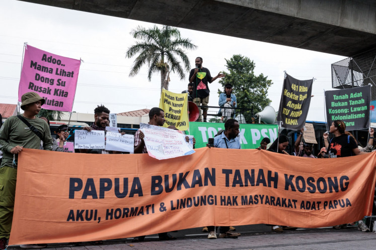 Demonstrators hold a banner reading &ldquo;Papua is not vacant land&rdquo; on Oct. 7, 2025, during a rally in front of the Agrarian and Spatial Planning Ministry office in South Jakarta against a plan to release forest areas in South Papua for national strategic projects (PSN) on food, energy and defense.