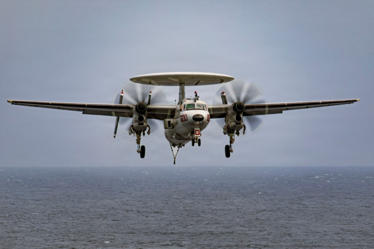 This US Navy handout photo released on March 18, 2026 by US Central Command public affairs, shows an E-2D Hawkeye aircraft, attached to Airborne Command and Control Squadron 124, preparing to land on the flight deck of the world's largest aircraft carrier, USS Gerald R. Ford (CVN 78), during Operation Epic Fury, on March 15, 2026. 