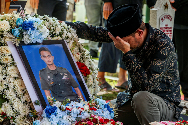 A relative reacts next to the grave of Zulmi Aditya Iskandar, a United Nations Interim Force in Lebanon (UNIFIL) peacekeeper killed in Lebanon, after the funeral ceremony at Cikutra Heroes Cemetery in Bandung, West Java, April 5, 2026.