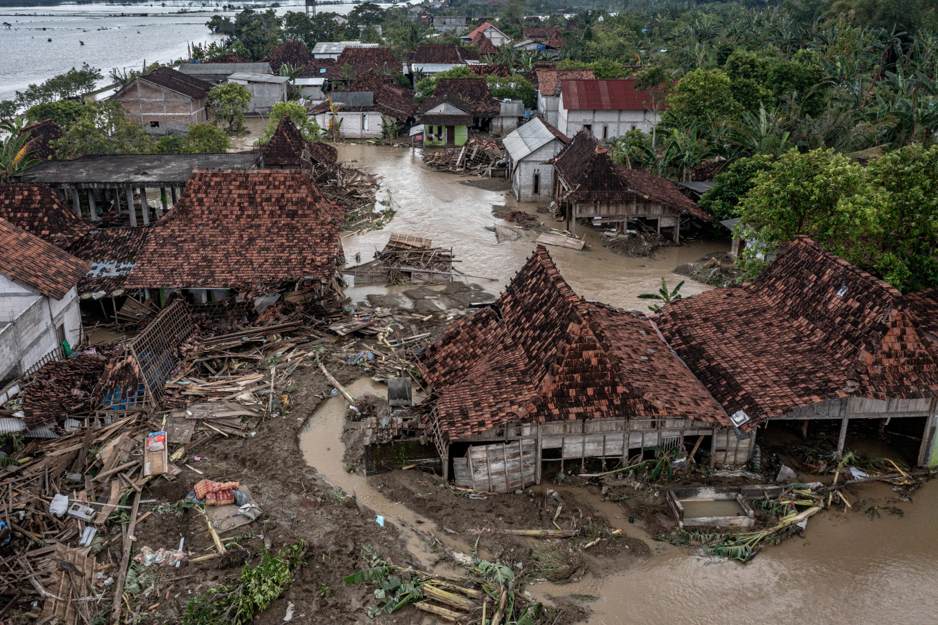 Homes damaged by flash floods in an aerial shot on April 4, 2026, after the Tuntang River embankment collapsed in Trimulyo village, Demak regency, Central Java. Official data reported thousands of displaced residents and collapsed homes in at least four districts of the regency. 